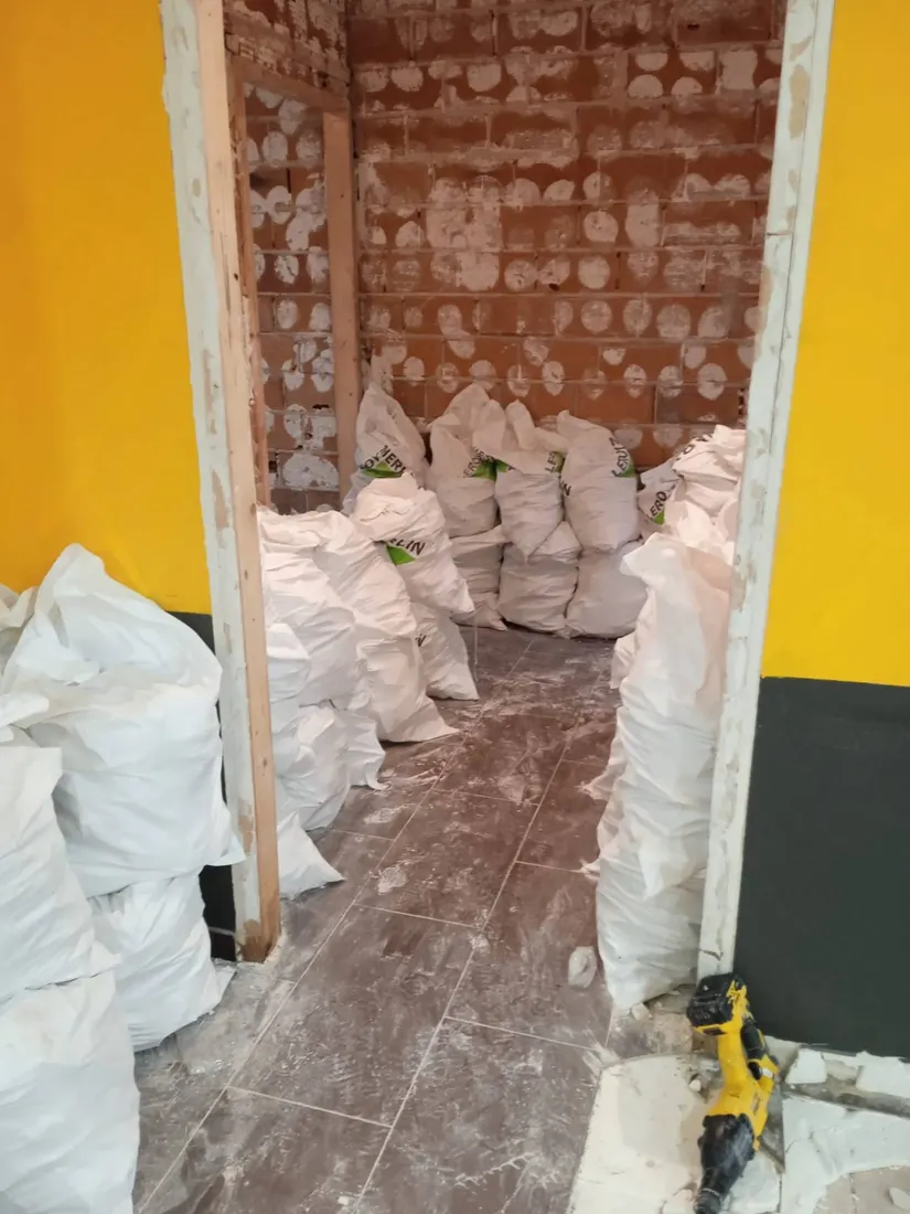 Sacos de escombro acumulados en una puerta de un local en obras